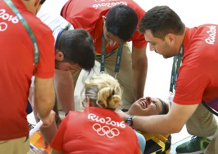 2016 Rio Olympics - Cycling Track - Preliminary - Team training - Rio Olympic Velodrome - Rio de Janeiro, Brazil - 08/08/2016. Australia's (AUS) women's team member Melissa Hoskins is aided after a crash during a practice session. REUTERS/Paul Hanna