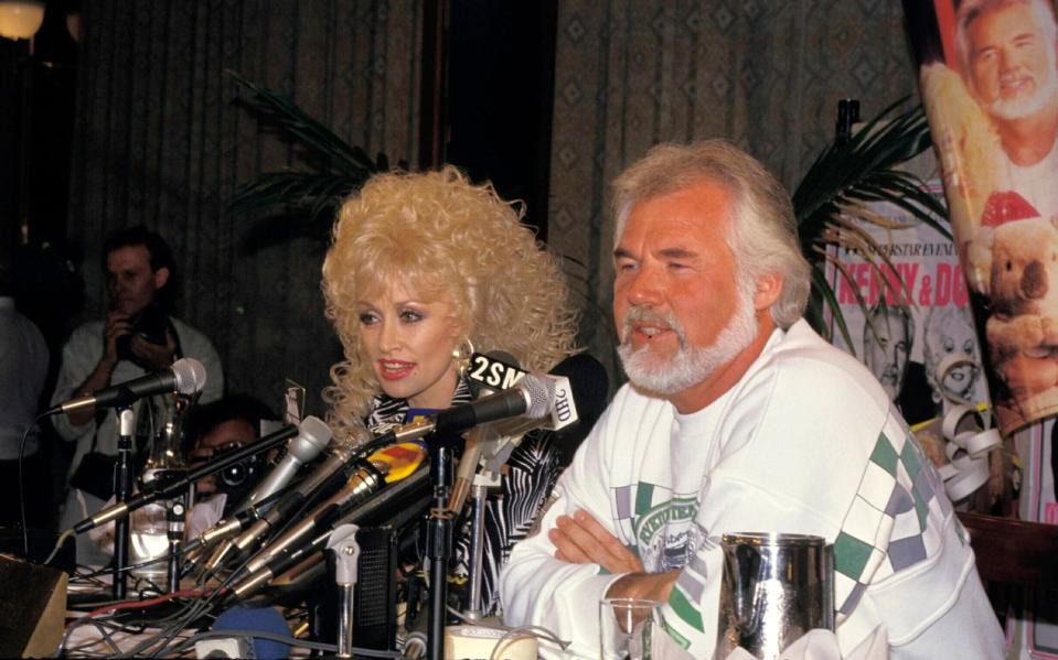 Nicht nur Country-, sondern auch Fernsehstar: Parton (hier mit Kenny Rogers, 1987) trat schon in den 60-ern im US-Fernsehen auf, hatte später zwei nach ihr benannte Shows und sorgte dann auch im Kino für Aufsehen: Für ihre Performance in der Komödie "9 to 5" (1980) wurde sie mit zwei Grammys ausgezeichnet, außerdem war sie für einen Oscar ("Best Original Song") nominiert. (Bild: Getty Images/Patrick Riviere)