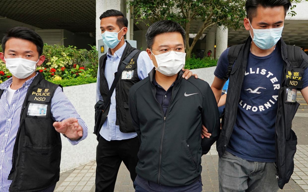 Ryan Law, second from right, Apple Daily's chief editor, is arrested by police officers in Hong Kong  - AP