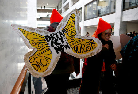 Protesters calling for an immigration bill addressing the so-called Dreamers, young adults who were brought to the United States as children, walk through the Hart Office Building on Capitol Hill in Washington, U.S., January 16, 2018. REUTERS/Joshua Roberts