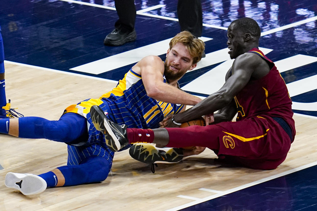 Indiana Pacers forward Domantas Sabonis (11) and Cleveland Cavaliers center Thon Maker (14) go to the floor for a loose ball during the second half of an NBA basketball game in Indianapolis, Thursday, Dec. 31, 2020. (AP Photo/Michael Conroy)