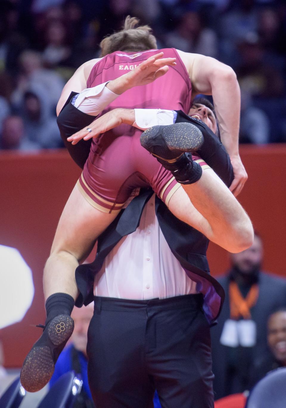 Dunlap's Nick Mueller jumps into the arms of coach Rick Mathern after his 4-2 decision over Vernon Hills' Illia Dvoriannikov in the 165-pound title match of the Class 2A state wrestling championships Saturday, Feb. 17, 2024 at the State Farm Center in Champaign.