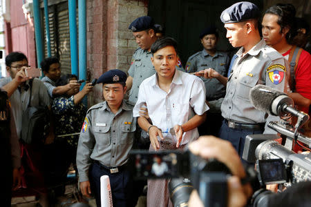 Detained Reuters journalist Kyaw Soe Oo speaks to the media, while escorted by police, after a court hearing in Yangon, Myanmar May 22, 2018. REUTERS/Ann Wang