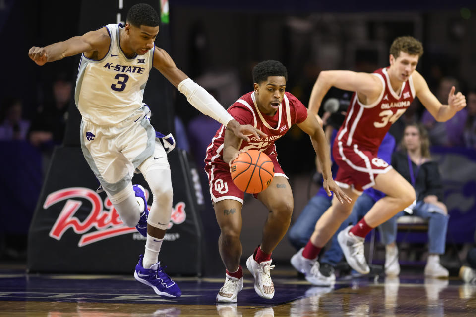 Kansas State forward David N'Guessan (3) ties to steal the ball from Oklahoma guard Grant Sherfield during the first half of an NCAA college basketball game in Manhattan, Kan., Wednesday, March 1, 2023. (AP Photo/Reed Hoffmann)