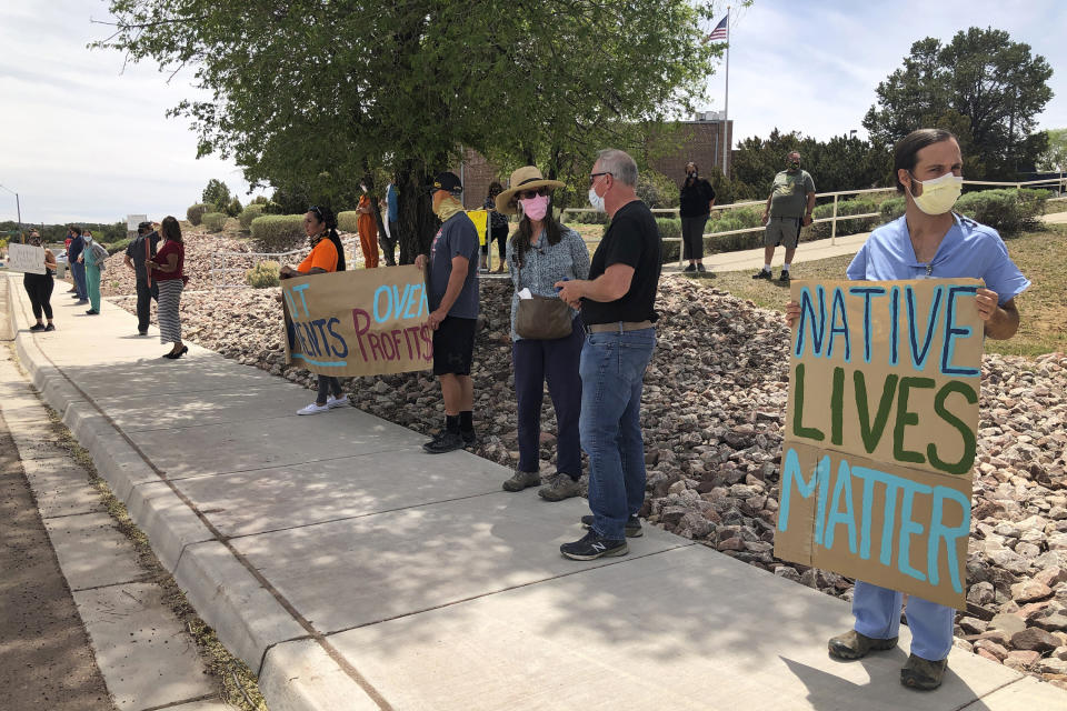 In this May 8, 2020, photo, medical staff from Rehoboth McKinley Christian Hospital including physician Neil Jackson, right, hold a protest over working conditions and depleted staff in Gallup, N.M. Many nurses and doctors say staffing at the hospital was inadequate because of hospital CEO David Conejo's move to cut back on nurses in the first week of March to offset declining hospital revenues after elective surgeries were suspended. They voiced their discontent at the recent protest calling for his resignation. (AP Photo/Morgan Lee)