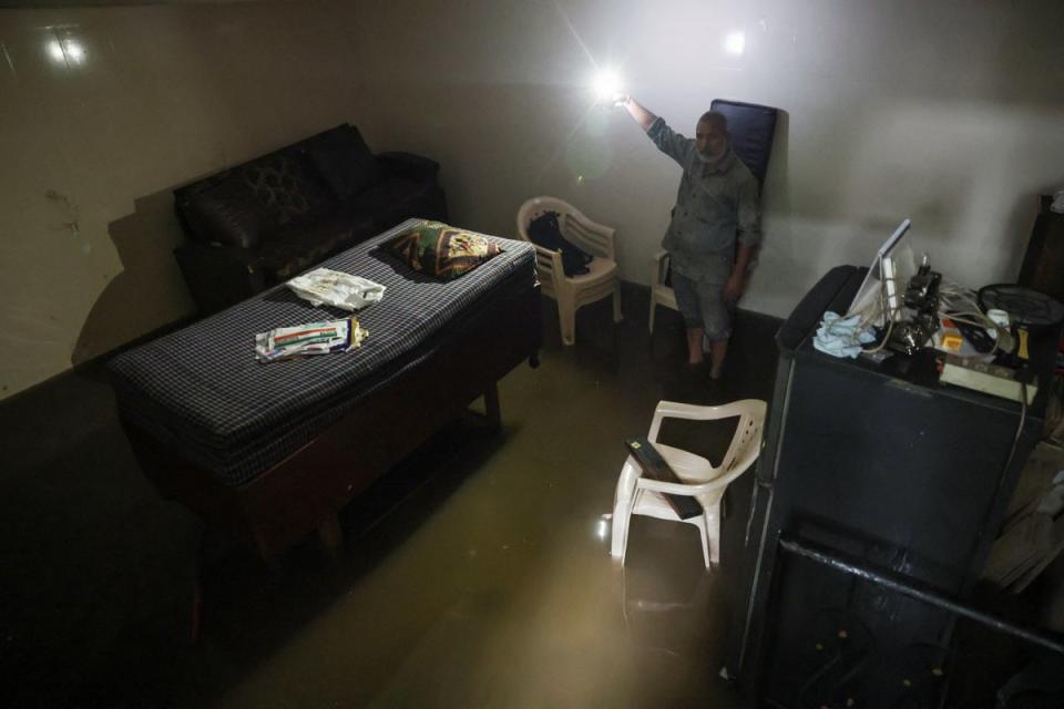 A man shows his flooded house after heavy rains in New Delhi on 8 July (REUTERS)