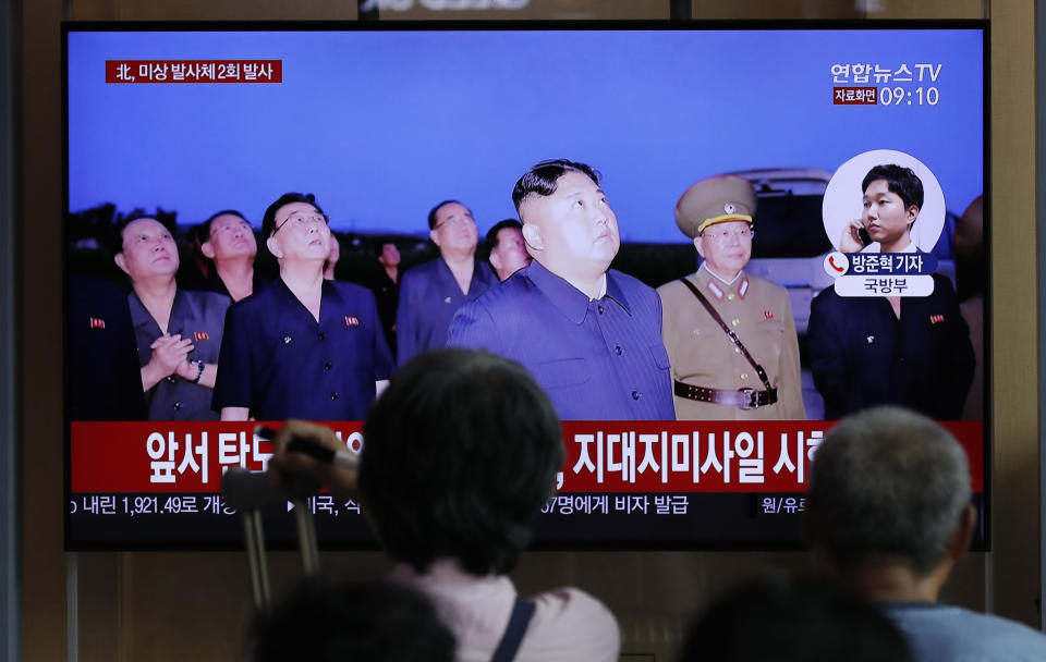 People watch a TV news program reporting about North Korea's firing projectiles with a file image of North Korean leader Kim Jong Un at the Seoul Railway Station in Seoul, South Korea, Friday, Aug. 16, 2019. South Korea's military said Friday North Korea fired more projectiles into the sea to extend a recent streak of weapons tests believed to be aimed at pressuring Washington and Seoul over slow nuclear diplomacy. The letters read on the top "North Korea, fired two unidentified projectiles." (AP Photo/Lee Jin-man)