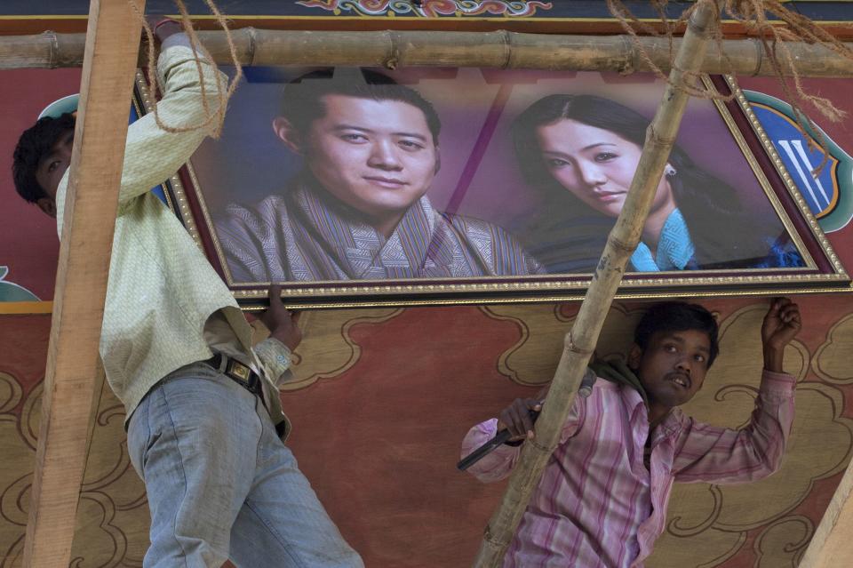 Men hang a portrait of Bhutan's king and fiancee on an archway in Bhutan's capital Thimphu