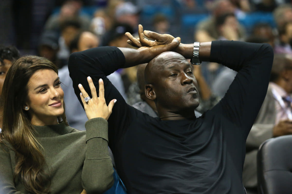 Michael Jordan sitting with his wife Yvette Prieto at a Hornets game.