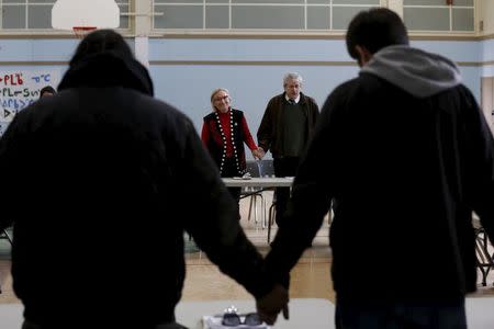 Canada's Indigenous Affairs Minister Carolyn Bennett (L) and New Democratic Party MP Charlie Angus take part in a prayer at the start of a meeting with youth in the Attawapiskat First Nation in northern Ontario, Canada, April 18, 2016 after a suicide crisis state of emergency was declared. REUTERS/Chris Wattie