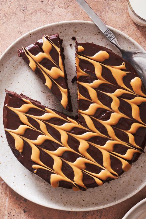 <p>We gave the classic <a href="https://www.delish.com/cooking/recipe-ideas/a19473626/best-flourless-chocolate-cake-recipe/" rel="nofollow noopener" target="_blank" data-ylk="slk:flourless chocolate cake;elm:context_link;itc:0;sec:content-canvas" class="link ">flourless chocolate cake</a> an upgrade in the form of LOTS of peanut butter. The chocolate and PB combo make it even richer than the original, while being just as easy to make. The fancy stripes are optional—but who doesn't love a little extra peanut butter?!</p><p>Get the <strong><a href="https://www.delish.com/cooking/recipe-ideas/a36339267/flourless-peanut-butter-chocolate-cake-recipe/" rel="nofollow noopener" target="_blank" data-ylk="slk:Flourless Peanut Butter Chocolate Cake recipe;elm:context_link;itc:0;sec:content-canvas" class="link ">Flourless Peanut Butter Chocolate Cake recipe</a></strong>. </p>