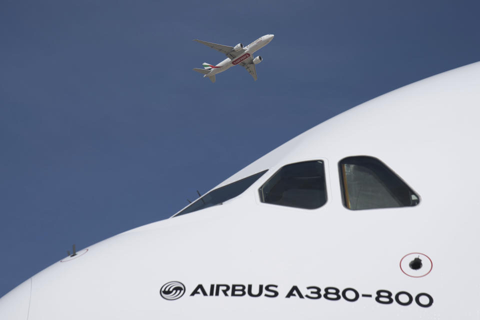 An Emirates cargo flight takes off over an Emirates Airbus A380 on display at the Dubai Air Show in Dubai, United Arab Emirates, Monday, Nov. 13, 2023. Long-haul carrier Emirates opened the Dubai Air Show with a $52 billion purchase of Boeing Co. aircraft, showing how aviation has bounced back after the groundings of the coronavirus pandemic, even as Israel's war with Hamas clouds regional security. (AP Photo/Jon Gambrell)