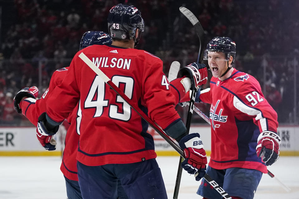 Washington Capitals center Evgeny Kuznetsov (92) celebrates his goal with right wing Tom Wilson, and others during the first period of the team's NHL hockey game against the Colorado Avalanche, Tuesday, Oct. 19, 2021, in Washington. The Capitals won 6-3. (AP Photo/Alex Brandon)