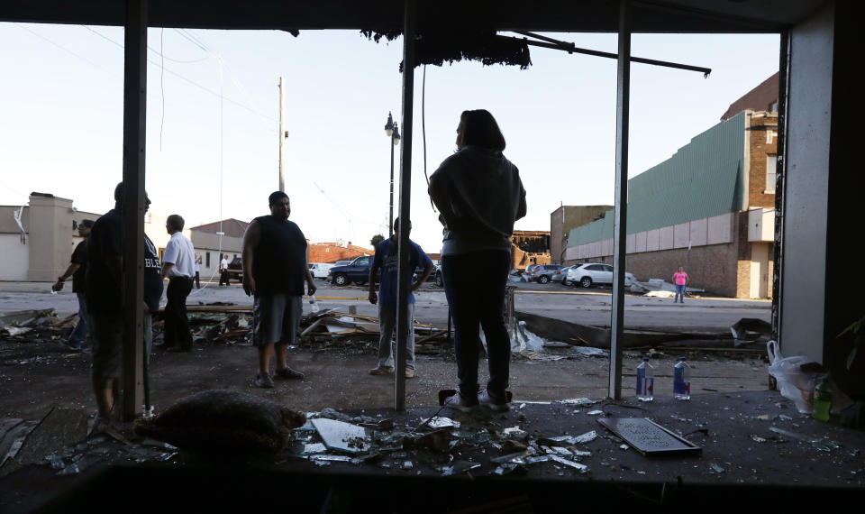 <p>Juan Moz, of Marshalltown, Iowa, helps clean out a tornado-damaged business on Main Street, Thursday, July 19, 2018, in Marshalltown, Iowa. Several buildings were damaged by a tornado in the main business district in town including the historic courthouse. (Photo: Charlie Neibergall/AP) </p>