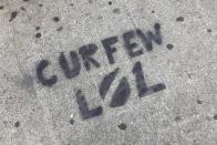 A sidewalk is spray painted with graffiti about New York City's curfew order, in the Brooklyn borough of New York, Tuesday, June 2, 2020. In New York City, nonviolent demonstrations against police brutality, sparked by the death of George Floyd at the hands of police in Minneapolis, were punctuated by people smashing storefront windows near Rockefeller Center and breaching the doors into the storied Macy's store, littering parts of Manhattan with broken glass. (AP Photo/Mark Lennihan)