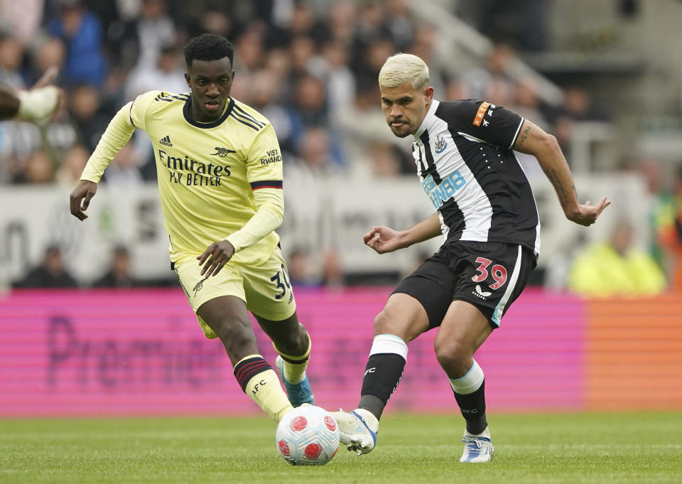 Arsenal's Eddie Nketiah, left and Newcastle United's Bruno Guimaraes in action during the English Premier League soccer match at St. James' Park, Newcastle upon Tyne, England, Monday May 16, 2022. (Owen Humphreys/PA via AP)