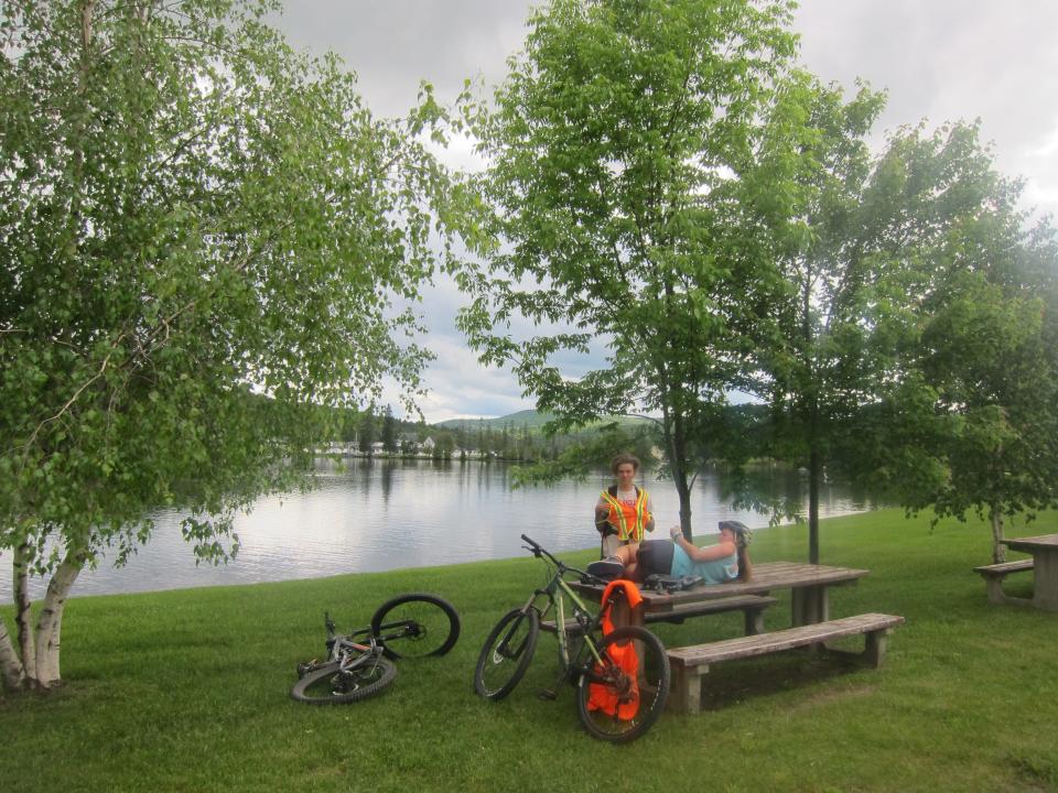 Cyclists relax on the shore of Joe's Pond in West Danville on the Lamoille Valley Rail Trail, as seen on June 19, 2023.