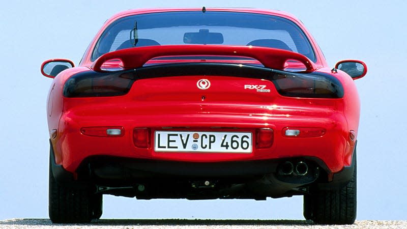 A photo of the rear end on a red Mazda RX-7. 