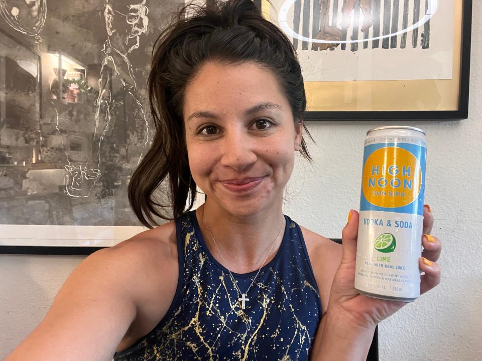 chelsea holding a can of lime high noon seltzer