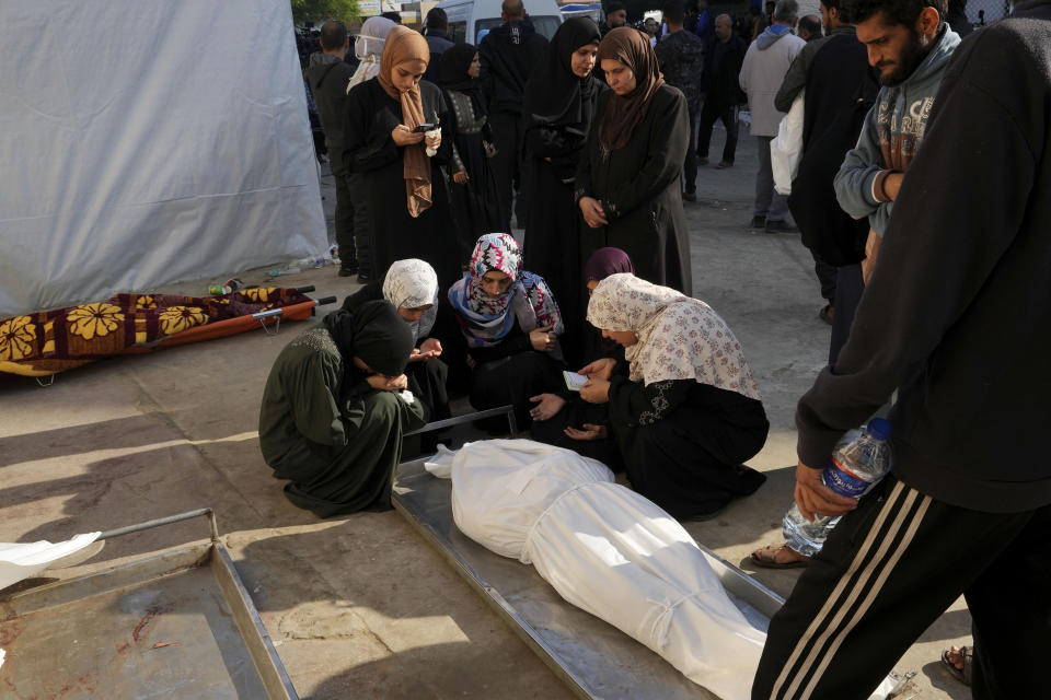 Palestinian mourn relatives were killed in the Israeli bombardment of the Gaza Strip in Deir al Balah on Friday, Dec. 1, 2023. AP Photo/Adel Hana)