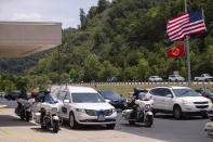 The hearse flanked by motorcycle police prepares to take the body of Floyd County Deputy William Petry from the Mountain Arts Center to the cemetery in Prestonsburg, Ky., Tuesday, July 5, 2022. Dep. Petry and two Prestonsburg city police officers were killed while serving a warrant at a home in the county. (Silas Walker/Lexington Herald-Leader via AP)