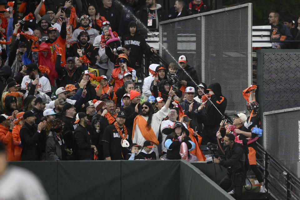 Baltimore Orioles owner David Rubenstein (wearing white cap), lower right, sprays the crowd during a baseball game between the Orioles and the Arizona Diamondbacks, Friday, May 10, 2024, in Baltimore. (AP Photo/Nick Wass)