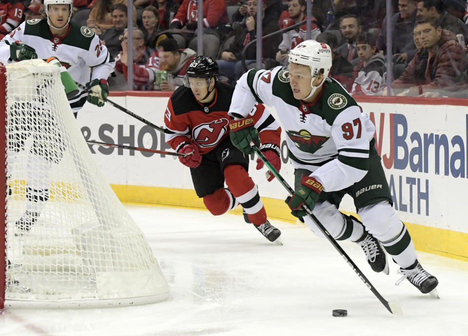 Minnesota Wild left wing Kirill Kaprizov (97) skates with the puck as he is pursued by New Jersey Devils left wing Jesper Bratt (63) during the first period of an NHL hockey game Wednesday, Nov.24, 2021, in Newark, N.J. (AP Photo/Bill Kostroun)