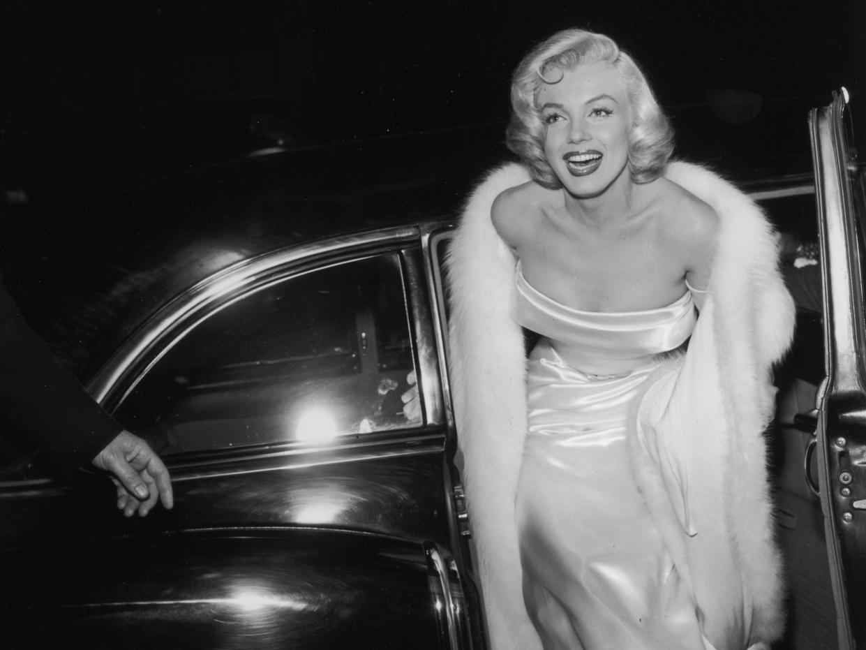 1954: EXCLUSIVE American actor Marilyn Monroe (1926 - 1962) emerges from a car, wearing a strapless white gown and white fur coat at the premiere of director Walter Lang's film 'There's No Business Like Show Business'. (Photo by M. Garrett/Murray Garrett/Getty Images)