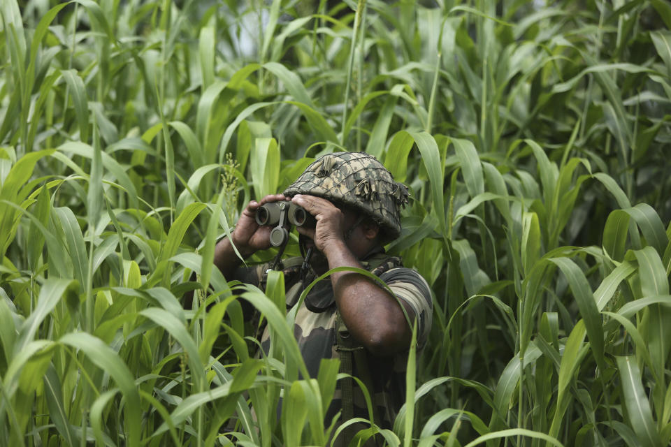 FILE - In this Aug. 13, 2019, file photo, an Indian Border Security Force (BSF) soldier keeps vigil near the India Pakistan border at Garkhal in Akhnoor, about 35 kilometers (22 miles) west of Jammu, India. Guns have fallen silent along the Line of Control, a de facto border that divides the Himalayan region of Kashmir between India and Pakistan after the rivals in February, 2021 reaffirmed their 2003 cease-fire accord. The somewhat surprising decision has prompted a thaw in the otherwise turbulent relations between the nuclear-armed South Asian neighbors, raising questions about how long the fragile peace will last. (AP Photo/Channi Anand, File)