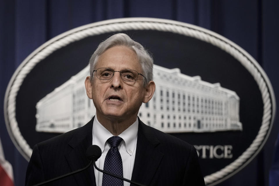 Merrick Garland at the microphone, in front of the seal of the Justice Department.
