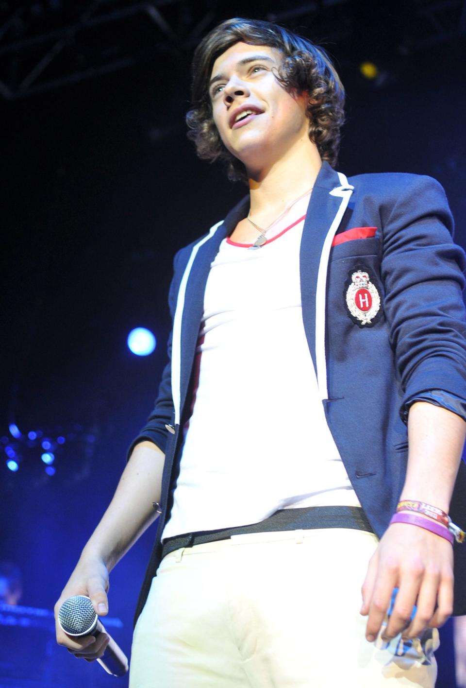 Harry Styles wears a purple Believe in Magic wristband in concert in 2011 (Shutterstock)