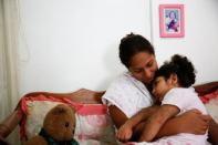 Lusnay Echezuria, abraza a su hija Arioska Torres de tres años en su casa en Caracas. La niña tiene una enfermedad neurológica y es tratada con anticonvulsivos. REUTERS/Carlos Garcia Rawlins. 30 de enero de 2017