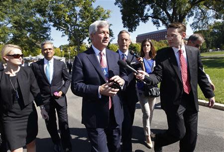 Jamie Dimon (C), Chairman and CEO of JPMorgan Chase, is questioned by journalists as he and other CEOs arrive at the White House in Washington October 2, 2013, for a meeting of the Financial Services Forum with U.S. President Barack Obama. REUTERS/Jason Reed