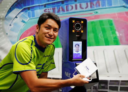 NEC Green Rockets' rugby player Teruya Goto poses with the face recognition system for Tokyo 2020 Olympics and Paralympics, which is developed by NEC corp, during its demonstration in Tokyo, Japan August 7, 2018. REUTERS/Toru Hanai
