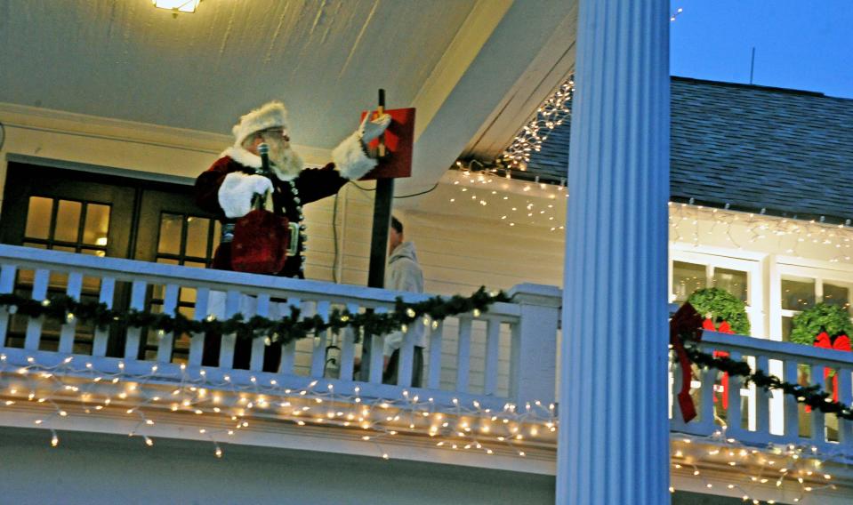 Santa flips the switch to light the Smith Orr Homestead Christmas lights to start the festivities in Orrville Friday.