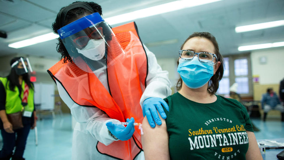 A nurse receives a dose of the coronavirus vaccine 