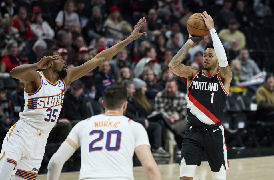 Portland Trail Blazers guard Anfernee Simons, right, looks to shoot over Phoenix Suns forward Kevin Durant, left, during the second half of an NBA basketball game in Portland, Ore., Sunday, Jan. 14, 2024. (AP Photo/Craig Mitchelldyer)