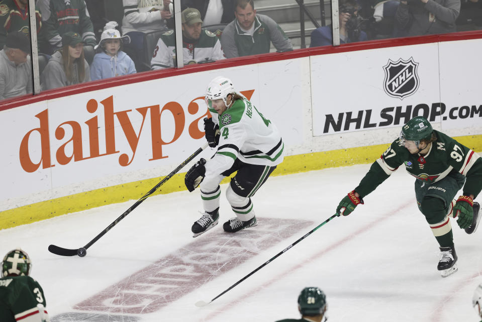 Dallas Stars defenseman Miro Heiskanen (4) handles the puck against Minnesota Wild left wing Kirill Kaprizov (97) during the first period of Game 4 of an NHL hockey Stanley Cup first-round playoff series Sunday, April 23, 2023, in St. Paul, Minn. (AP Photo/Stacy Bengs)