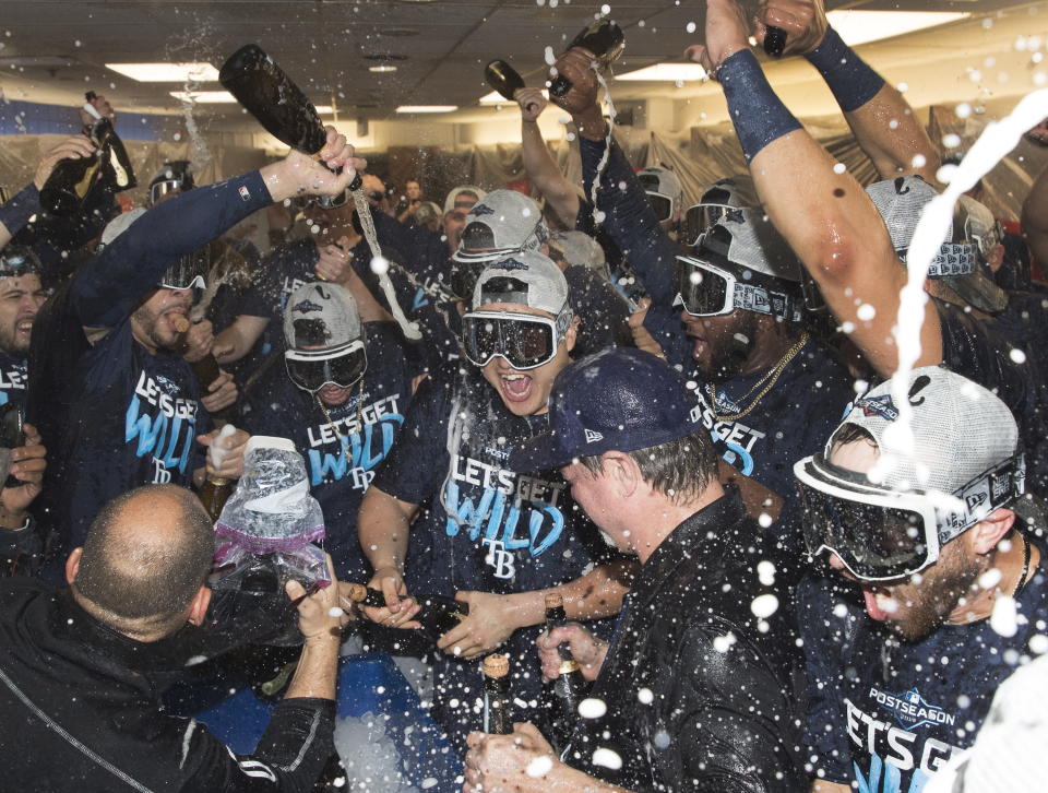 Tampa Bay Rays players celebrate in the clubhouse after they defeated the Toronto Blue Jays and clinched an MLB American League wild-card berth in Toronto, Friday, Sept. 27, 2019. (Fred Thornhill/The Canadian Press via AP)