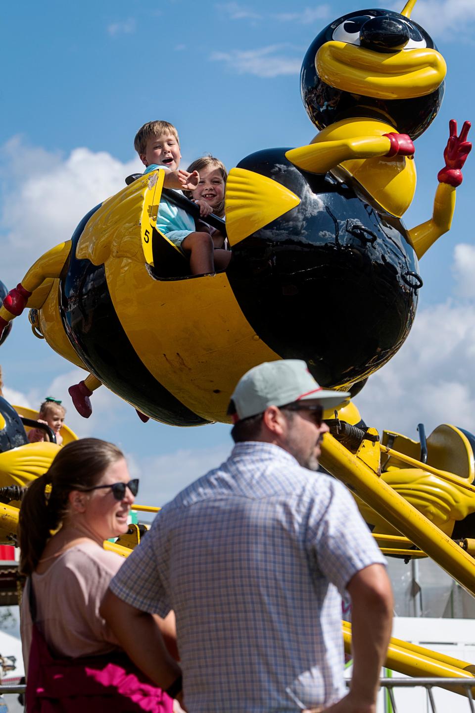 George Yoho, 5, waves to his parents, Emily and Andy, as he flies by on a ride at the NC Mountain State Fair, September 8, 2023.