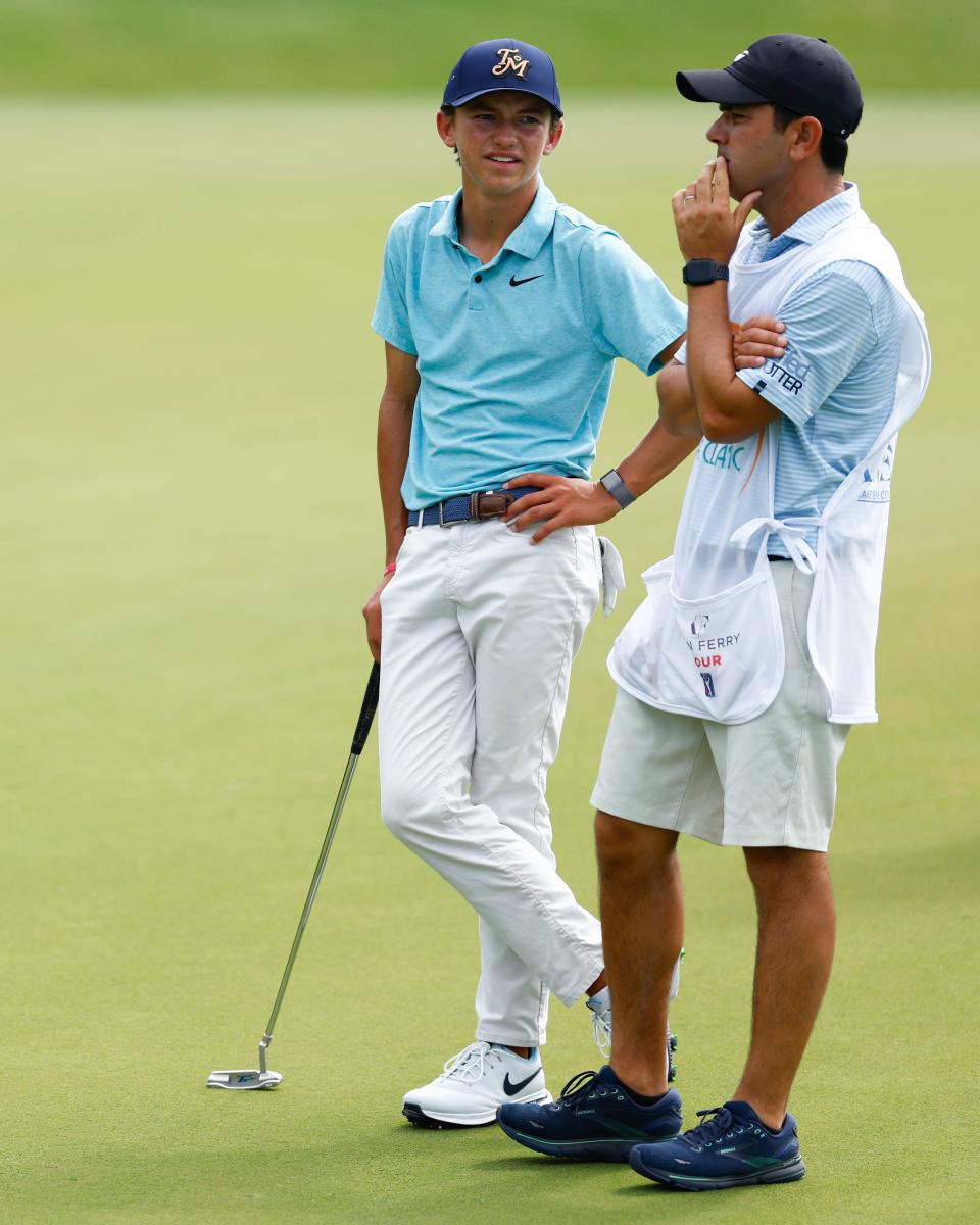 Miles Russell talks strategy with swing coach and caddie Ramon Bescansa during the first round of the LECOM Suncoast Classic at Lakewood National Golf Club Commander Course on April 18 in Lakewood Ranch, Florida.