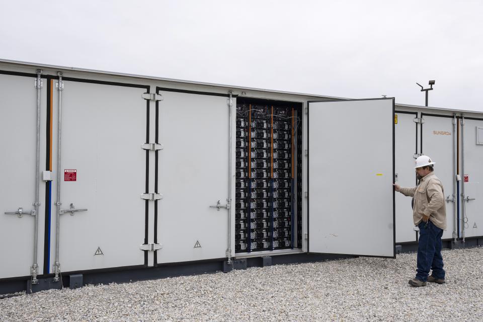 An employee works at a battery energy storage facility in Saginaw, Texas, April 25, 2023, that is owned and operated by Eolian L.P. Eolian will begin construction later this year in Portland, Ore., on projects to serve Portland General Electric, the utility that serves metropolitan Portland, the largest battery procurement of their kind outside California. (AP Photo/Sam Hodde)