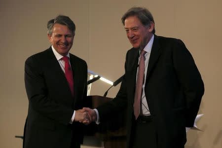 Ben van Beurden (L), chief executive officer of Royal Dutch Shell, shakes hand with Andrew Gould, chairman of the BG Group, during a news conference at the London Stock Exchange, April 8, 2015. REUTERS/Stefan Wermuth