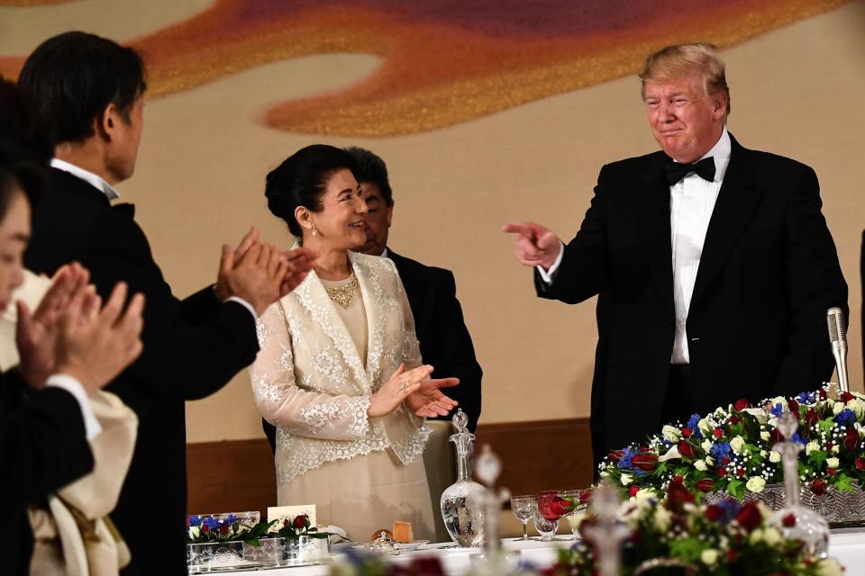 President Donald Trump gestures standing next to Japan's Empress Masako during a state banquet at the Imperial Palace in Tokyo on May 27, 2019.