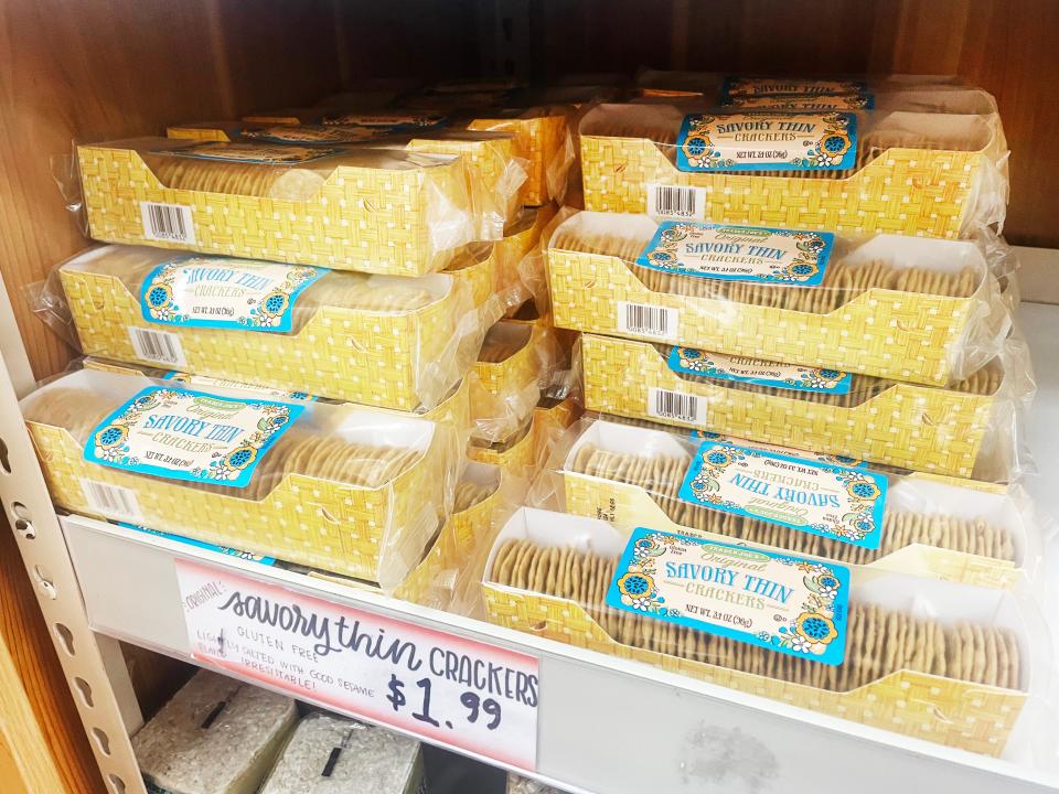 Yellow boxes of crackers with blue labels on gray shelves at Trader Joe's