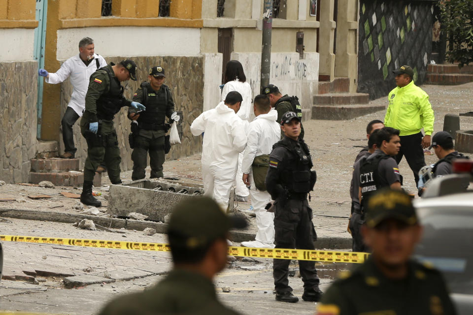 CORRECTS TO TWO DOZEN POLICE OFFICERS INJURED AND NO DEATHS - Police and investigators inspect the site where a homemade bomb exploded near the Santamaria bull ring in Bogota, Colombia, Sunday, Feb. 19, 2017. The artefact was detonated just a few hours before a scheduled bullfight, as police in riot gear were congregating ahead of a demonstration by animal rights activists. An official police statement said that 26 people suffered shrapnel and blast injuries, all but two of them officers. (AP Photo/Ricardo Mazalan)