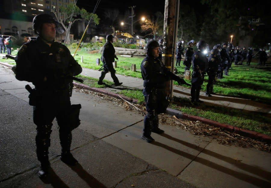 Police descend on People’s Park as crews cut down trees and people are asked to leave in Berkeley, Calif., on Thursday, Jan. 4, 2024. Police officers in riot gear removed activists and crews put in shipping containers to wall off the historic park overnight as the University of California, Berkeley waits for a court ruling it hopes will allow it to build much-needed student housing. (Jane Tyska/Bay Area News Group via AP)