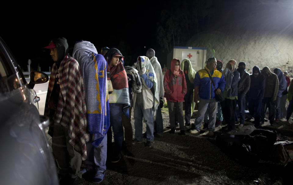 FILE - In this Aug. 31, 2018 file photo, Venezuelan migrants line up for free bread and coffee, donated by a Colombian family from their car, at a gas station in Pamplona, Colombia. Carlos Valdes, director of Colombia's national forensic institute, believes hypothermia has killed some migrants as they trek through the mountain tundra region, but he had no idea how many. (AP Photo/Ariana Cubillos)