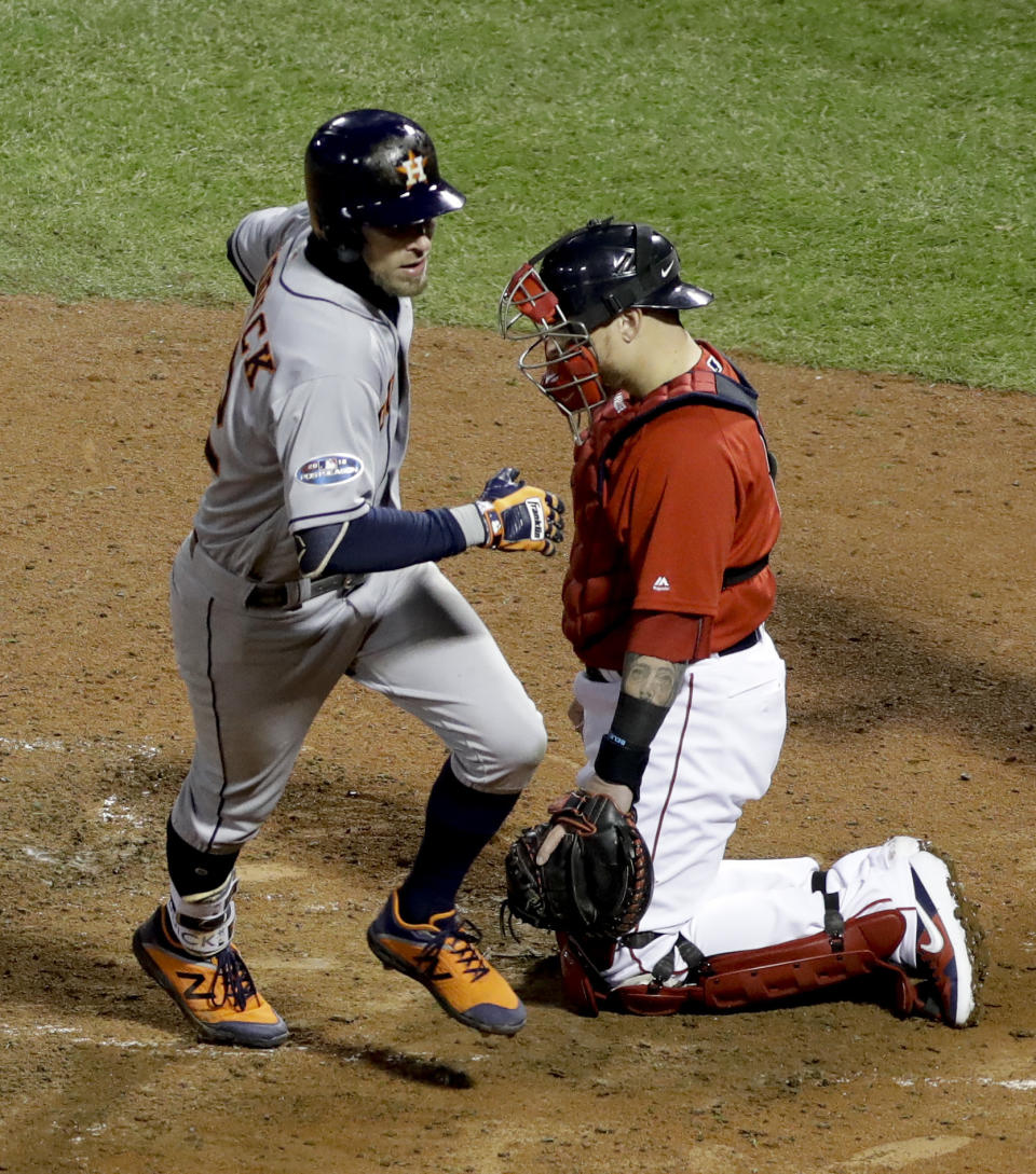 Houston Astros' Josh Reddick scores past Boston Red Sox catcher Christian Vazquez after a home run during the ninth inning in Game 1 of a baseball American League Championship Series on Saturday, Oct. 13, 2018, in Boston. (AP Photo/David J. Phillip)