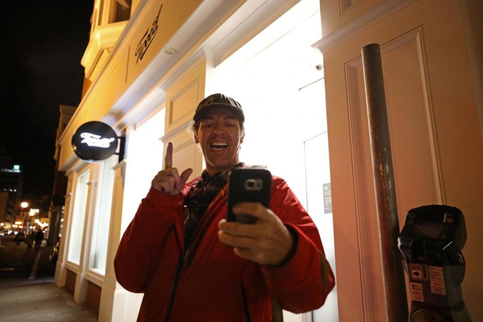 Ian Power takes a selfie outside the Tweed store as he lines up to purchase legal recreational marijuana in St John's, Newfoundland (Chris Wattie/Reuters)